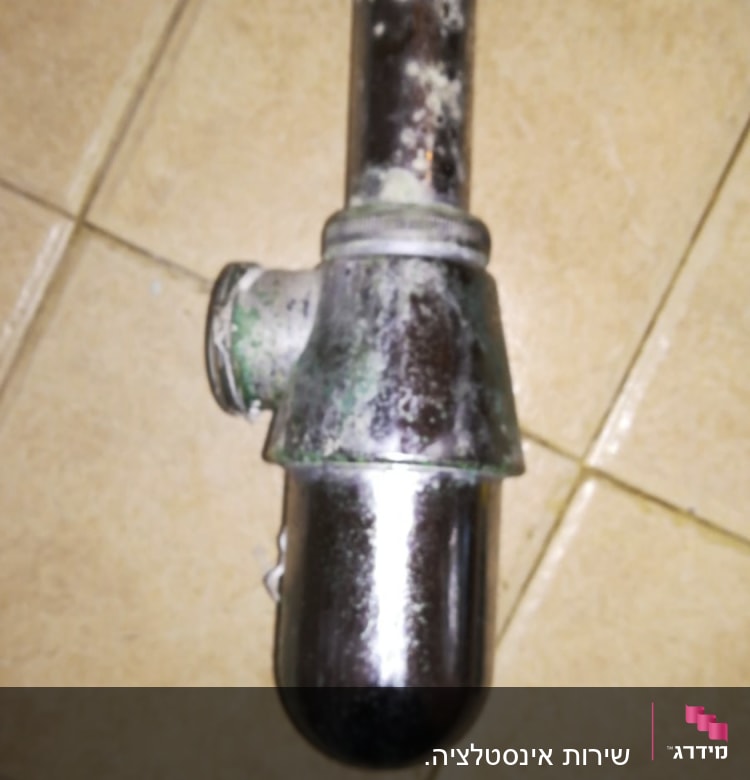 צינור מתכת חלוד על רצפת קרמיקה